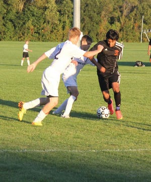 Fabian Lopez of Sturgis looks to move around Three Rivers defenders Monday night in soccer action.
