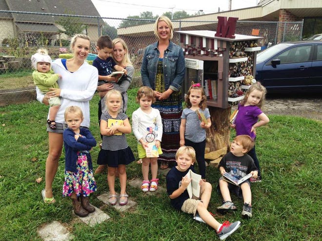 A new Little Free Library was set up earlier this month on the north side of the Manchester School for Young Children, 5221 S.W. 15th Court. Pictured in front of the library are, front row from left, Aviana Mezera, Katerina Garrett, Autumn Fike, Carter Beougher, Alyssia Turner, Ronan Monaco and Kahlan Garrison. From left, back row, Cora Mezera, being held by her mother, Megan Mezera; Cade Hamilton, being held by teacher Cherie Hopkins; and Christina Turner, owner and teacher at the school.
