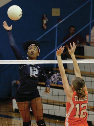PG's #12 Ashley Ceasar spikes the ball as RHS's #12 Kendal Hamilton goes up for the block at Randleman on Tuesday, September 22,2014. PJ Ward-Brown/The Courier-Tribune