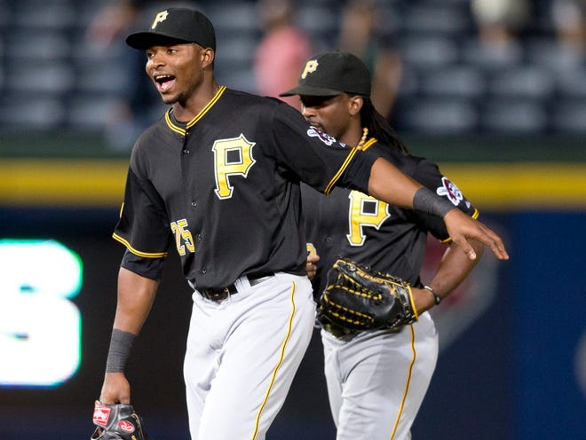 Pittsburgh outfielders Gregory Polanco (25) and Andrew McCutchen run off the field after defeating the Braves in Atlanta on Tuesday night to clinch a playoff berth.
