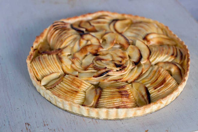 This Sept. 8, 2014, photo shows French apple tart in Concord, N.H. When slicing the apple stop each slice when you're still about 1/4 inch from the surface of the cutting board. According to chef Sara Moulton it is easier to slice an apple thinly when each slice remains attached at the bottom.