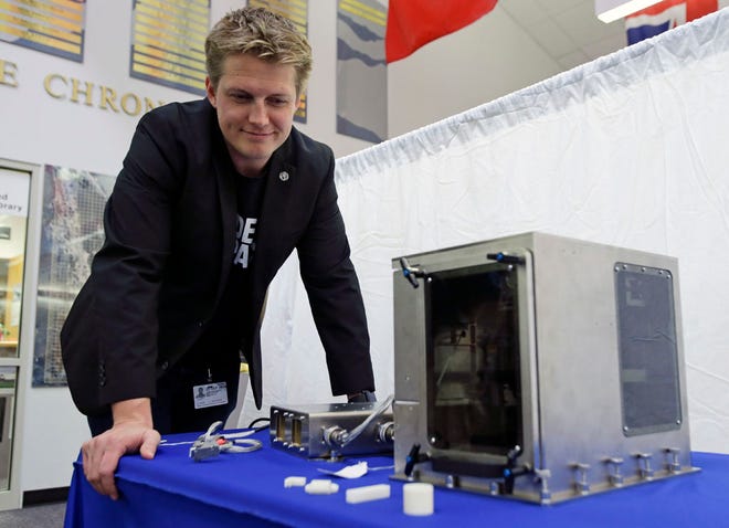 Brad Kohlenberg, a business development engineer with Made In Space, looks over a 3-D printer identical to the one that will be transported to the International Space Station aboard the Falcon 9 SpaceX rocket at the Kennedy Space Center in Cape Canaveral, Fla., Friday, Sept. 19, 2014.