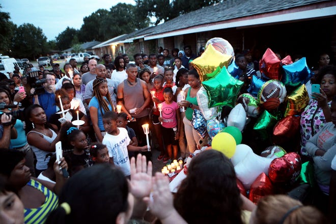 Residents gather Wednesday night for a vigil in memory of 14-year-old Cameron, who was shot and killed by a Terrebonne sheriff's deputy the night before. The vigil was held outside the vacant home where he was killed, on Kirkglen Loop in the Village East neighborhood near Houma.