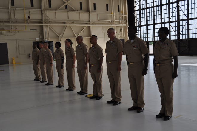 NAS Jax Chief petty officer (CPO) selectees stand at attention before family and friends prior to being officially pinned as CPOs during a ceremony at Hangar 117 on Sept. 16. (From left) BMC David Brown, ACC Dax Bonnett, AEC Larry Renew, LSC Kimberly McClam, MAC Carly Bohannon, OSC Luis Huerta, CSC Nelson Albores, ENC Chad Burnett, ABEC Dequinton Baker, CSC Stacey Washington.