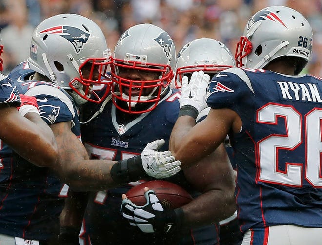New England Patriots defensive tackle Dominique Easley, left, and cornerback Logan Ryan (26) congratulate defensive tackle Vince Wilfork, center, on his interception in the fourth quarter of Sunday's game against the Oakland Raiders in Foxborough, Mass. The Patriots won 16-9. AP photo