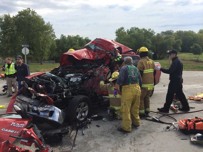 Firefighters examine a vehicle, mangled in a wreck on US 75 highway Wednesday.