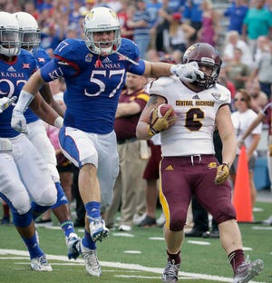 Kansas linebacker Jake Love, leftg, celebrates after forcing Central Michigan running back Saylor Lavallii, right out of bounds for a loss of yards during the second half of a game last Saturday in Lawrence. Kansas won 24-10.
