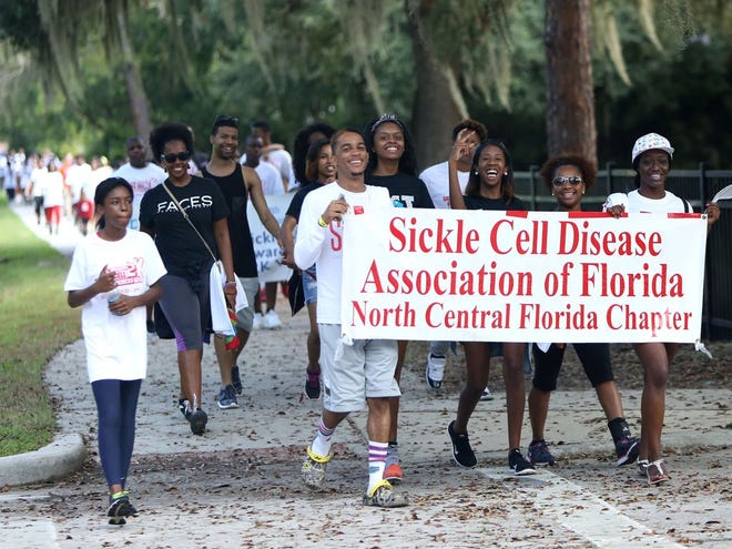 Walkers take part in the fourth annual “Walking to Win!” Sickle Cell Awareness 2K Walk along a path at T.B .McPherson Park, where there were speakers, music, lunch and information booths.