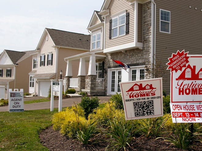 Signs welcome visitors to a model home as construction is under way on Sept. 10 at a housing development in Zelienople, Pa. Average long-term U.S. mortgage rates rose slightly this week but remained near their lows for the year.