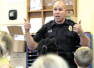 Massillon police Sgt. Jason Saintenoy looks for thumbs up Thursday to check if the children at the YMCA child care class understand what he taught about bullying and what to do if they should encounter bullying
