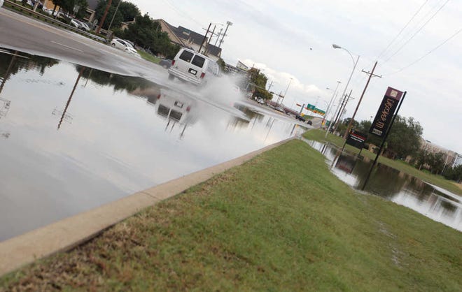 Rainwater spills over into Fourth Street on Thursday in Lubbock.