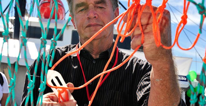 Skip Barlow tries his hand at net mending during the 2013 Working Waterfront Festival.