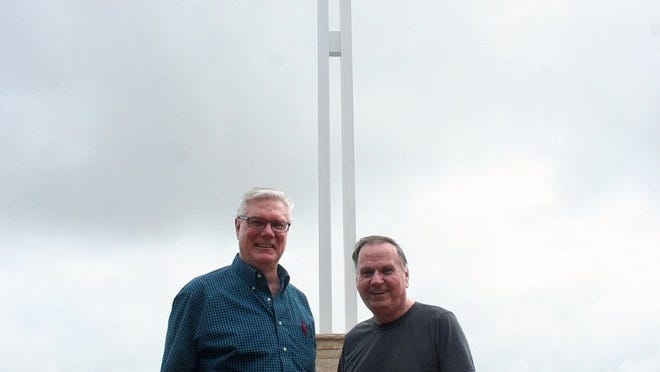 New Hope Community Church elder Rik Morris (left) and Associate Pastor Jack Hammans stand in front of a 40-foot metal cross, erected this summer and overlooking much of Round Rock.