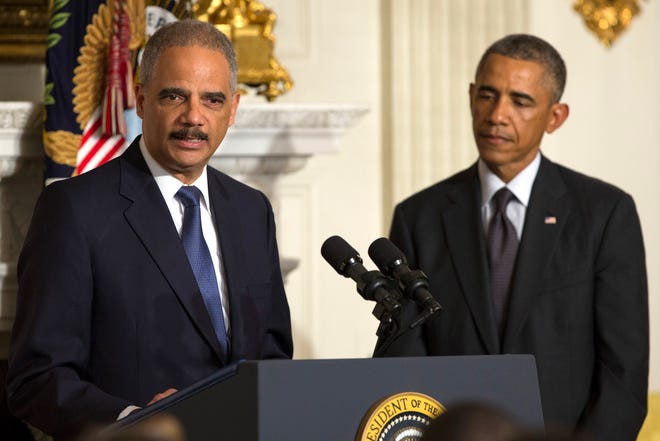 President Barack Obama, right, looks on as Attorney General Eric Holder speaks Thursday in the State Dining Room of the White House in Washington. Holder, who served as the public face of the Obama administration's legal fight against terrorism and weighed in on issues of racial fairness, is resigning after six years on the job. He is the first black U.S. attorney general.