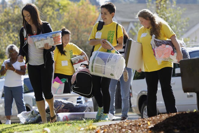 Marissa Ditler (left), a freshman from Woodland, Calif., leads a group of yellow-shirted helpers to her dorm room, including (from left) Rebecca Case, Aly Zahariev and Emily Orpin, during move-in day at the University of Oregon in Eugene on Thursday. (Andy Nelson/The Register-Guard)