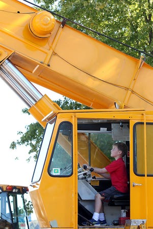Tommy Ghislandi looks up while seeing if he can operate a mobile crane during Hingham Nursery School's Touch a Truck event last year. This year's event is Saturday. Wicked Local Staff Photo by Robin Chan