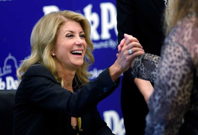 In this Sept. 11, 2014, photo, Texas Democratic gubernatorial candidate Wendy Davis visits with supporters at a book signing in Austin. Davis is expected to lose the Texas governor's race, but that could be a long-term win for Democrats. The state senator from Fort Worth has shattered fundraising records, breathed life into a Texas Democratic Party mired in the nation's longest political losing streak and stepped up to run in a race that looks unwinnable, buying time to groom a political bench that could face easier future elections.