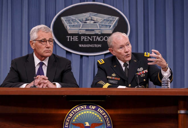 Joint Chiefs Chairman Gen. Martin Dempsey, right, and Defense Secretary Chuck Hagel brief reporters about ongoing operations against Islamic extremists in Syria and Iraq during a news conference at the Pentagon on Friday, Sept. 26, 2014. Dempsey testified to Congress earlier this month he may at some point recommend that ground troops be used to destroy the Islamic State militant operation. He told reporters today that the only force that can fight the Islamic State "would be comprised of Iraqis, Kurds and moderate Syrian opposition."