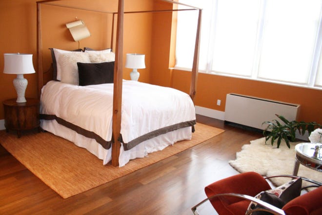 A soothing bedroom combining a husband's love of clean lines and white and a wife's favorite color, orange.