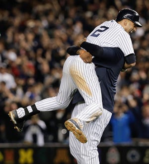 New York Yankees’ Derek Jeter, left, celebrates with C.C. Sabathia after driving in the game-winning run with a single against the Baltimore Orioles in the ninth inning of a baseball game Thursday in New York. The Yankees won 6-5 in Jeter’s final home game.