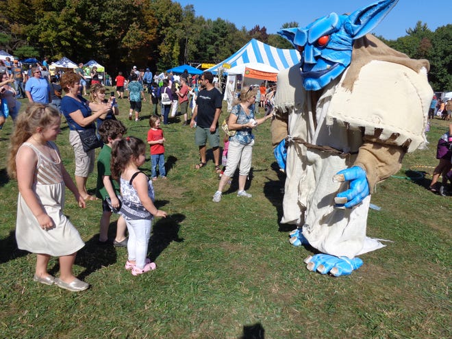 Addie, Gilbert and Gwyne Buie of Ware meet a troll from the Skeleton Crew Theater at the 16th annual North Quabbin Garlic and Arts Festival in Orange.