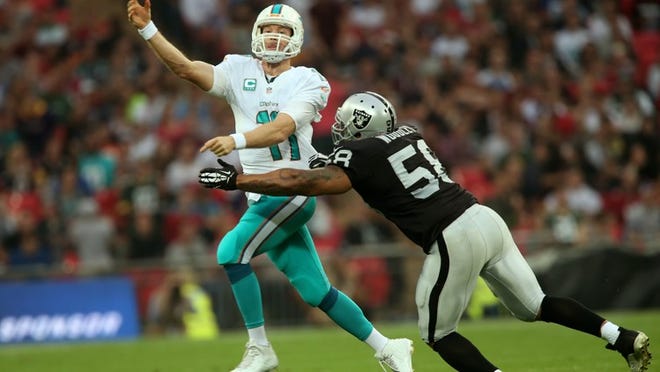 LONDON, ENGLAND - SEPTEMBER 28: Ryan Tannehill #17 of the Miami Dolphins passes as he is pressurised by LaMarr Woodley #58 of the Oakland Raiders during the NFL match between the Oakland Raiders and the Miami Dolphins at Wembley Stadium on September 28, 2014 in London, England. (Photo by Ben Hoskins/Getty Images)