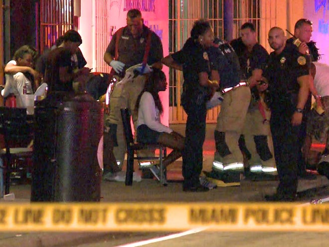 In this image taken from video, emergency personnel tend to the wounded outside The Spot, a nightclub in Miami, early Sunday, Sept. 28, 2014. Fifteen people were wounded in an early morning shooting at the club, including an 11-year-old, police said.