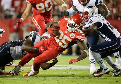 Kansas City Chiefs running back Jamaal Charles, center, runs with the ball as New England Patriots linebacker Jerod Mayo, left, and defensive back Malcolm Butler, right, defend during the third quarter of an NFL football game Monday, Sept. 29, 2014, in Kansas City, Mo. (AP Photo/Charlie Riedel)