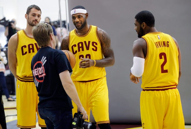 Clevleand Cavaliers' Kevin Love, left, LeBron James and Kyrie Irving (2) get ready for a photo shoot with Sports Illustrated during the NBA basketball team's media day Friday, Sept. 26, 2014, in Independence, Ohio. (AP Photo/Mark Duncan)