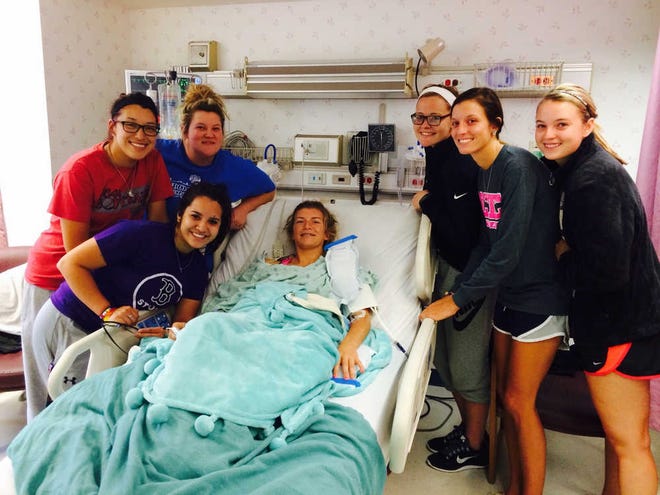 This photo provided by the family of Rachel Hitt shows Rachel Hitt, center, in her hospital room at the Norman Regional Hospital in Norman, Okla., Monday, Sept. 29, 2014, where she is being visited by her friends, former members of the North Central Texas College softball team. Hitt survived a deadly bus crash near Davis, Okla., on Friday, which killed four of her teammates. (AP Photo/Family of Rachel Hitt)