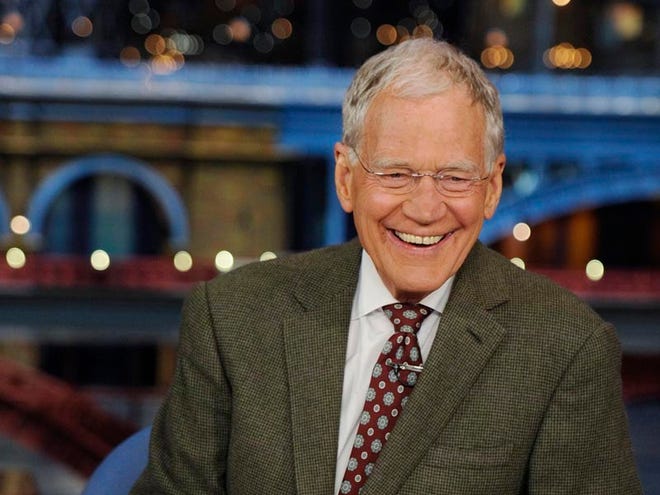In this photo provided by CBS, David Letterman, host of the “Late Show with David Letterman,” smiles while seated at his desk in New York on Thursday, April 3, 2014.