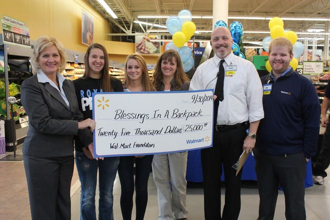 Sweetwater Principal Deb Follman, Sara Schwanke LRSC student volunteer, Parker Hoey DLHS volunteer, Laura McLaurin, School Counselor were all smiles Tuesday morning as they received a check from Walmart for $25,000 to help fund the Blessings in a Backpack program at area schools. Handing them the check are Walmart shift manager Randy Johnson and Walmart Asset Protection Manager Eric Lawson.