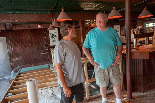 Kelley's Row co-owners Pat Duffy, left and Brian Kelley assess the damage inside the restaurant Row after backup of raw sewage and water began spouting from the restrooms in the cellar pub around 5 p.m. on Aug. 13.