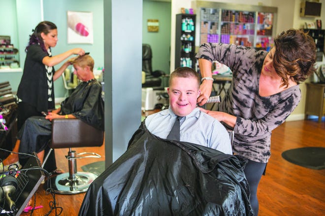 Rachel Prendergast cuts the hair of her 12-year-old son Eli at her salon, RaNew Salon, 580 Thames St., Newport. He didn’t want his hair cut at all for the first three years of his life. ‘I learned how to cut a moving target,’ Prendergast says.