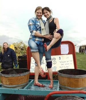 Steven David and Allison Archambauld stomp grapes at the Harvest Festival.