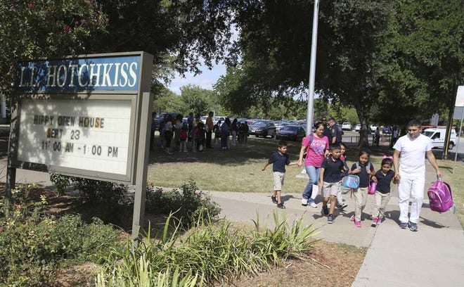 Children are picked up from L.L. Hotchkiss, Wednesday, Oct. 1, 2014, in Dallas, where children that were exposed to an Ebola infected family member attend classes. Authorities say five students who had contact with a man diagnosed with Ebola in Dallas are being monitored but are showing no symptoms of the disease. (AP Photo/LM Otero)