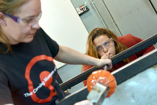 Chiara Chiosi looks to glass blower Jessi Moore while making a glass pumpkin during the San Giovanni Valdarno Sister Cities visit to the Corning Museum of Glass.