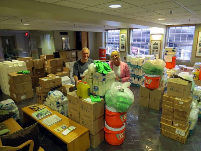 Wineglass Marathon co-directors Mark Landin and Sheila Sutton stand in piles of race supplies at the Corning Information Center. Roughly 6,000 runners will compete in the Wineglass 5K, half-marathon and marathon this weekend.
