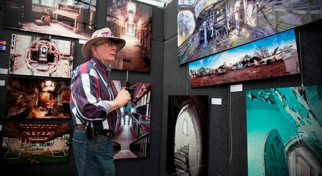 Michael Harrision, of Ocala, admires the photography work of artist Walter Arnold of Hendersonville, N.C., during last year's Ocala Fine Arts Festival. This year's event is set for Oct. 25-26.