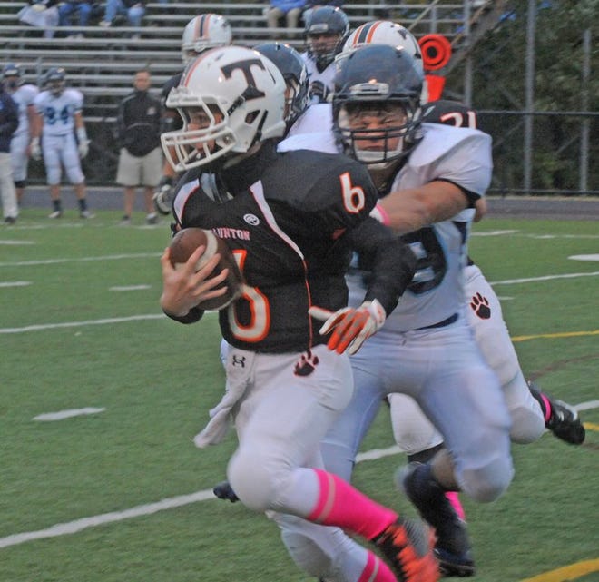 Taunton High quarterback Adam Leonard (6) looks to avoid a hit from a Franklin defender during Thursday's Hockomock League game at Taunton High School.