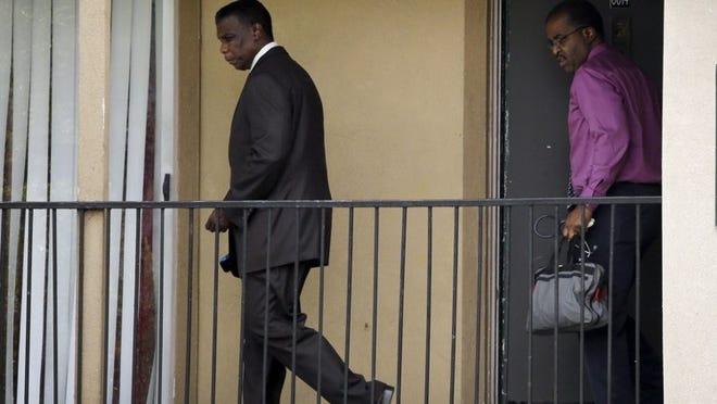 Dallas County Health and Human Services Director Zachary Thompson and Dr. Christopher Perkins walk out of an apartment unit at The Ivy apartment complex Thursday in Dallas. Dallas County officials have ordered family members who had contact with Thomas Eric Duncan, the patient diagnosed with Ebola, to stay inside their home.