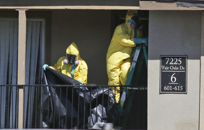 Hazardous material cleaners prepare to hang black plastic outside the apartment in Dallas on Friday, where Thomas Eric Duncan, the Ebola patient who traveled from Liberia to Dallas stayed last week.
