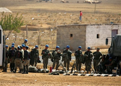 Turkish army's blue berrets stand close to the border line with Syria, near Suruc, Turkey, as fighting intensified nearby between Syrian Kurds and the militants of Islamic State group, Friday, Oct. 3, 2014. Turkey's parliament approved Thursday a motion that gives the government new powers to launch military incursions into Syria and Iraq and to allow foreign forces to use its territory for possible operations against the Islamic State group. (AP Photo/Burhan Ozbilici)