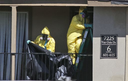 Hazardous material cleaners at the apartment where Thomas Eric Duncan, the Ebola patient who traveled from Liberia to Dallas, stayed last week. Duncan is being treated at an isolation unit at a Dallas hospital. The family living there has been confined under armed guard while being monitored by health officials. AP Photo/LM Otero