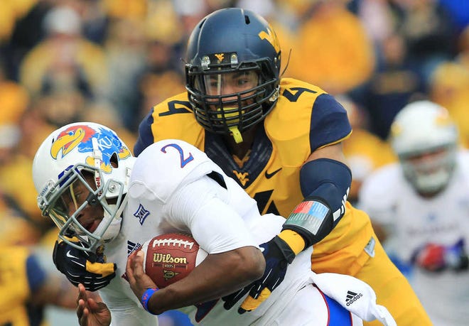 West Virginia's Shaquille Riddick (4) tackles Kansas quarterback Montell Cozart (2) during the first quarter of an NCAA college football game in Morgantown, W.Va., Saturday, Oct. 4, 2014.