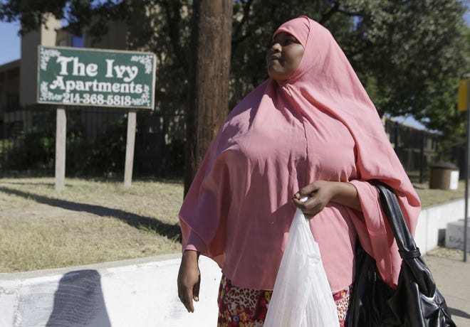 Shadiya Abdi, originally from Somalia, holds a shopping bag outside an apartment complex where Thomas Eric Duncan, the Ebola patient who traveled from Liberia to Dallas, stayed last week, Saturday, Oct. 4, 2014, in Dallas. According to Abdi, she has noticed that people have become stand-offish once they find out she is from Africa or they see her in her traditional dress.