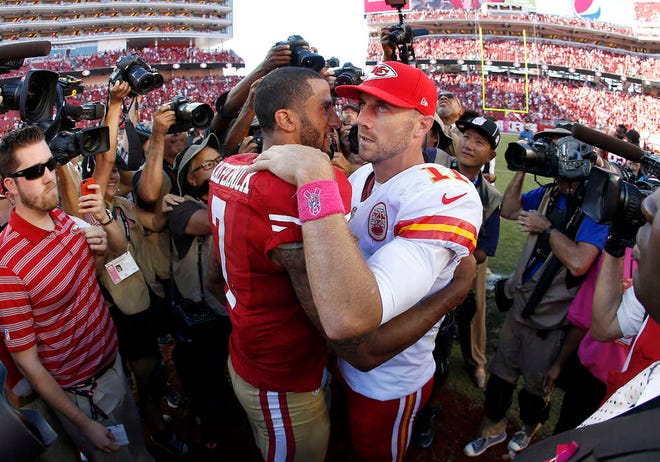 San Francisco 49ers quarterback Colin Kaepernick (7) hugs Kansas City Chiefs quarterback Alex Smith (11) after an NFL football game Sunday in Santa Clara, Calif. The 49ers won 22-17.