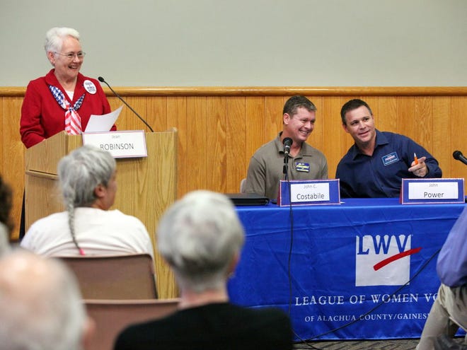 President of the League of Women Voters, Jean Robinson, left, introduces tax collector candidates Jon Costabile, center, and John Power during the League of Women Voters Candidate Forum at the Alachua County Library Headquarters on Monday in Gainesville.