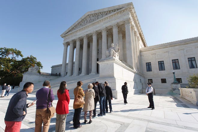 People wait to enter the Supreme Court in Washington, Monday, Oct. 6, 2014, as it begins its new term.
