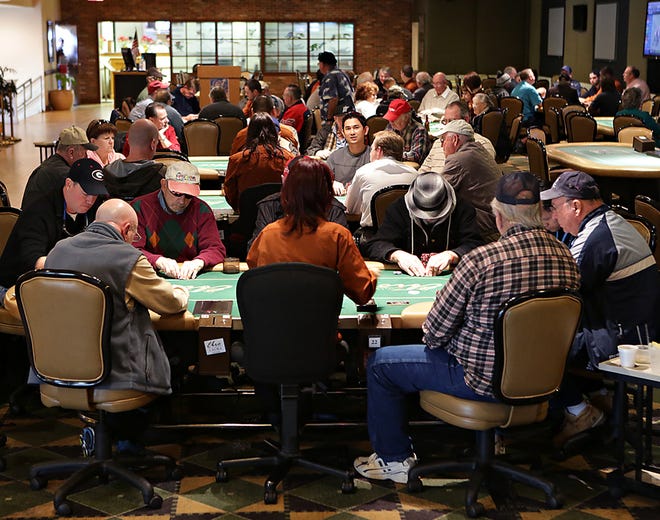 Patrons gather around multiple tables in the poker room at Ebro Greyhound Park in this file photo.